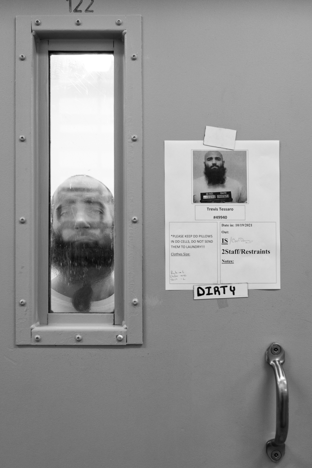 Face pressed against the window of a prison cell door